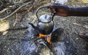This picture taken on November 30, 2020 shows a teapot placed at a campfire on land that was recently cleared at the Um Raquba camp in Sudan's eastern Gedaref province to make room to house more Ethiopian refugees fleeing fighting from Ethiopia's northern Tigray province.