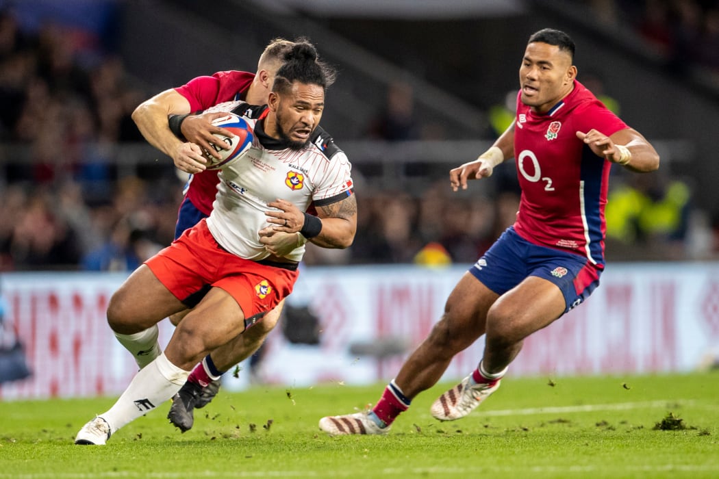 Tonga's Solomone Kata under pressure from Manu Tuilagi of England.
