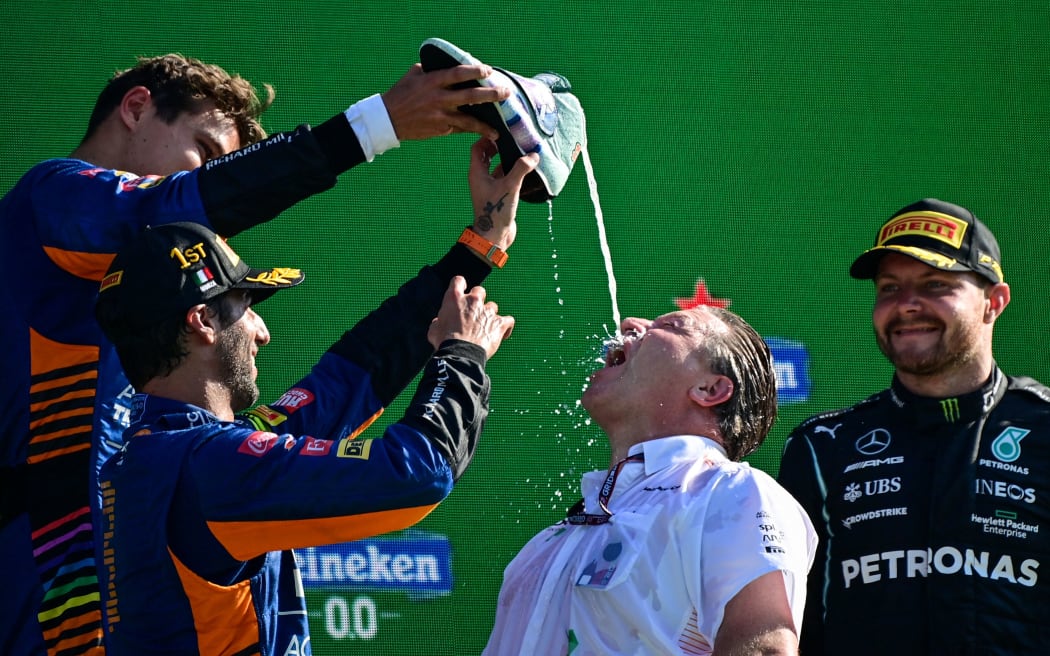 McLaren CEO Zak Brown celebrates with a 'shoey' after his drivers Daniel Ricciardo and Lando Norris finished first and second in the Italian Grand Prix at Monza, on September 12, 2021.