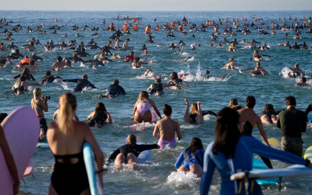 Thousands of people have gathered at Bondi Beach to paddle out into the water to hold a minute's silence for the victims killed during Sunday's attack.