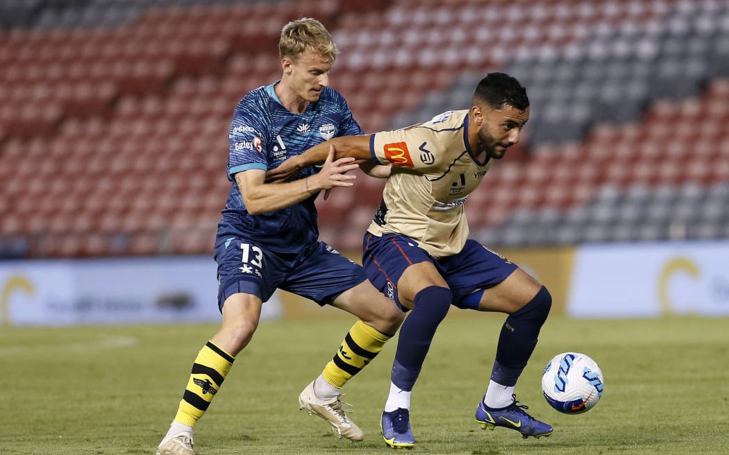 Mohamed Al Taay of the Jets holds off Nicholas Pennington of the Phoenix during the A-League match between the Newcastle Jets and Wellington Phoenix in 2022.