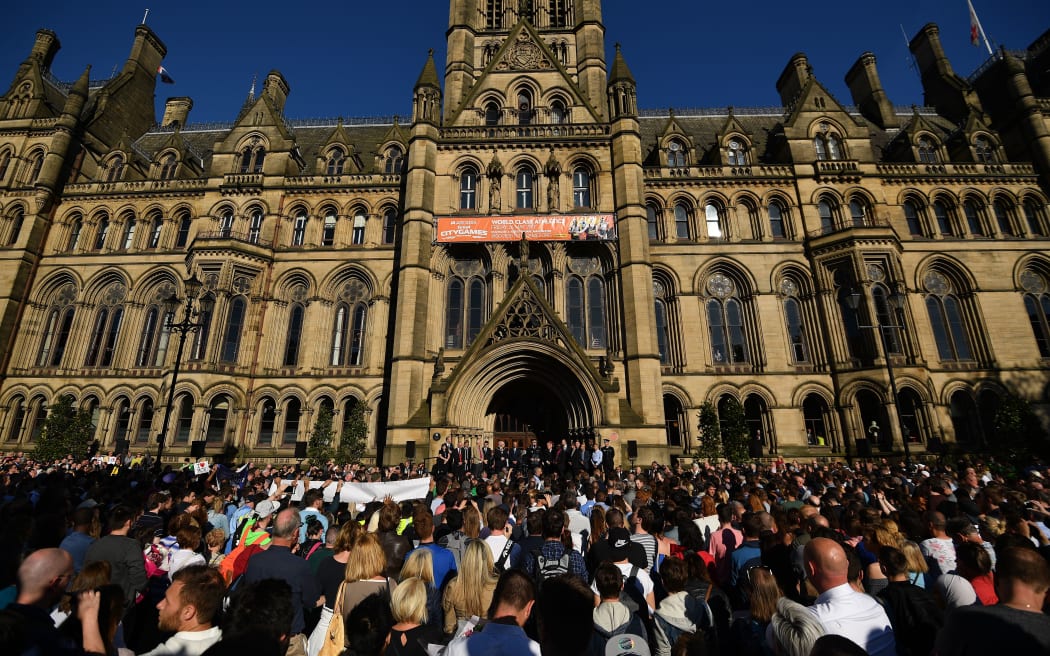 People attending a vigil at Albert Square in Manchester following the attack on Manchester Arena.