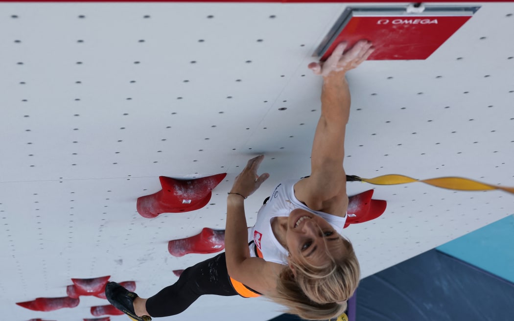An overview shows Poland's Aleksandra Miroslaw hitting the timer to make a world record as she competes in the women's sport climbing speed preliminary round's eliminiation heats during the Paris 2024 Olympic Games at Le Bourget Sport Climbing Venue in Le Bourget on August 5, 2024. (Photo by POOL / AFP)
