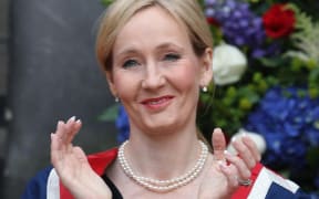 Harry Potter author J.K. Rowling applauds after receiving a Benefactor's Award from Britain's Princess Anne at an open air ceremony at the University of Edinburgh, Scotland, on September 26, 2011. The honour is in recognition of a £10 million donation made by Rowling to the university last year to establish a new multiple sclerosis (MS) research clinic. AFP PHOTO / DAVID CHESKIN / POOL (Photo by DAVID CHESKIN / POOL / AFP)