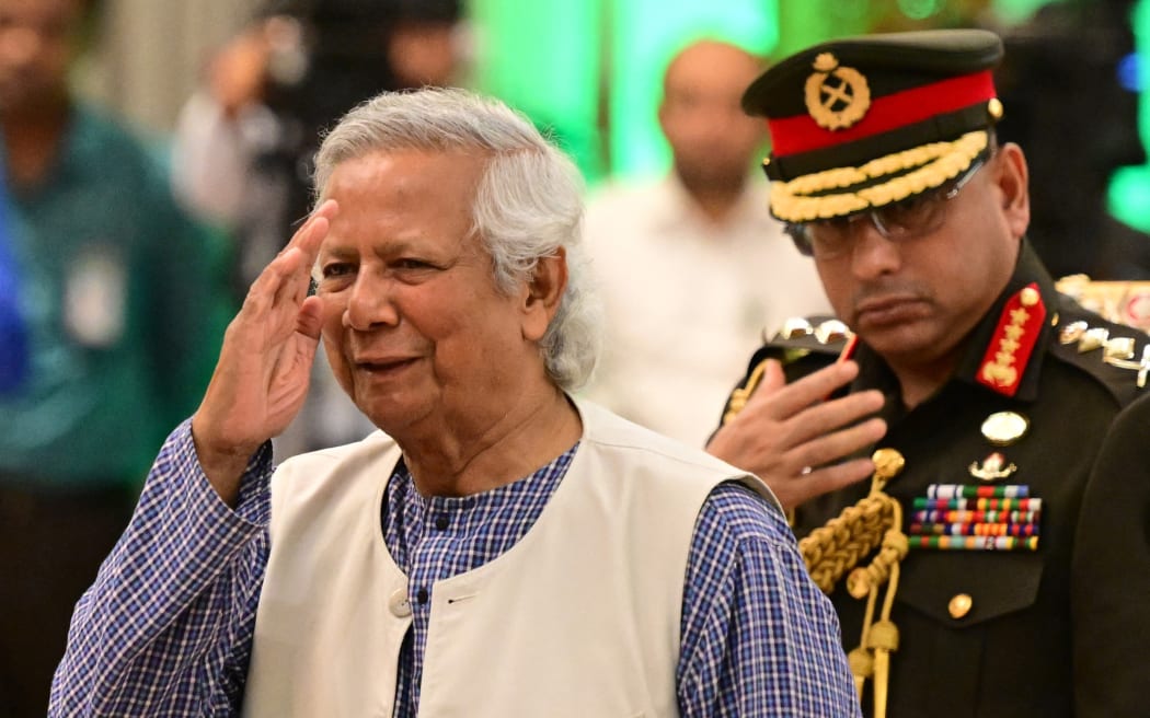 Nobel Peace Prize winner Muhammad Yunus (L) is sworn into office to lead Bangladesh's interim government as its chief adviser, days after a student-led uprising ended the 15-year rule of Sheikh Hasina, in Dhaka on August 8, 2024. (Photo by MUNIR UZ ZAMAN / AFP)