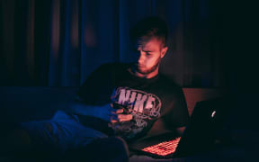 young man on laptop in the dark