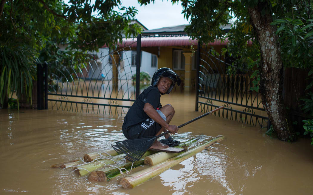 A man makes his way to his house submerged in floodwaters in Pengkalan Chepa, near Kota Bharu in north east Malaysia.