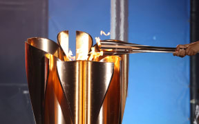 Flame delivered to the cauldron at a Tokyo Olympics.