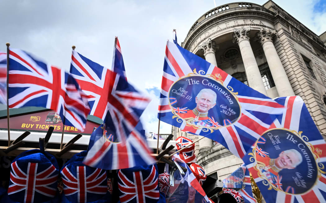 Union Jack flags and flags picturing Britain's King Charles III flap in the air as they are displayed at a street souvenirs vendor stall, in Trafalgar Square, central London, on May 5, 2023, ahead of the coronation weekend. - The country prepares for the coronation of Britain's King Charles III and his wife Britain's Camilla, Queen Consort on May 6, 2023.