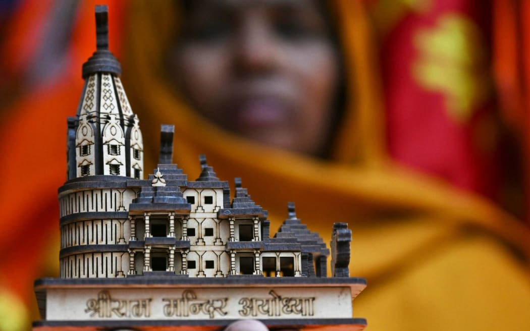 A shopkeeper displays a model of the Hindu temple to Ram ahead of its inauguration ceremony in Ayodhya. (Photo by Arun SANKAR / AFP)
