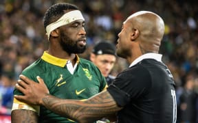 South African Captain Siya Kolisi speaks with Mark Tele’a of New Zealand.