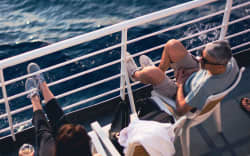 Two people sit aboard a cruise ship.