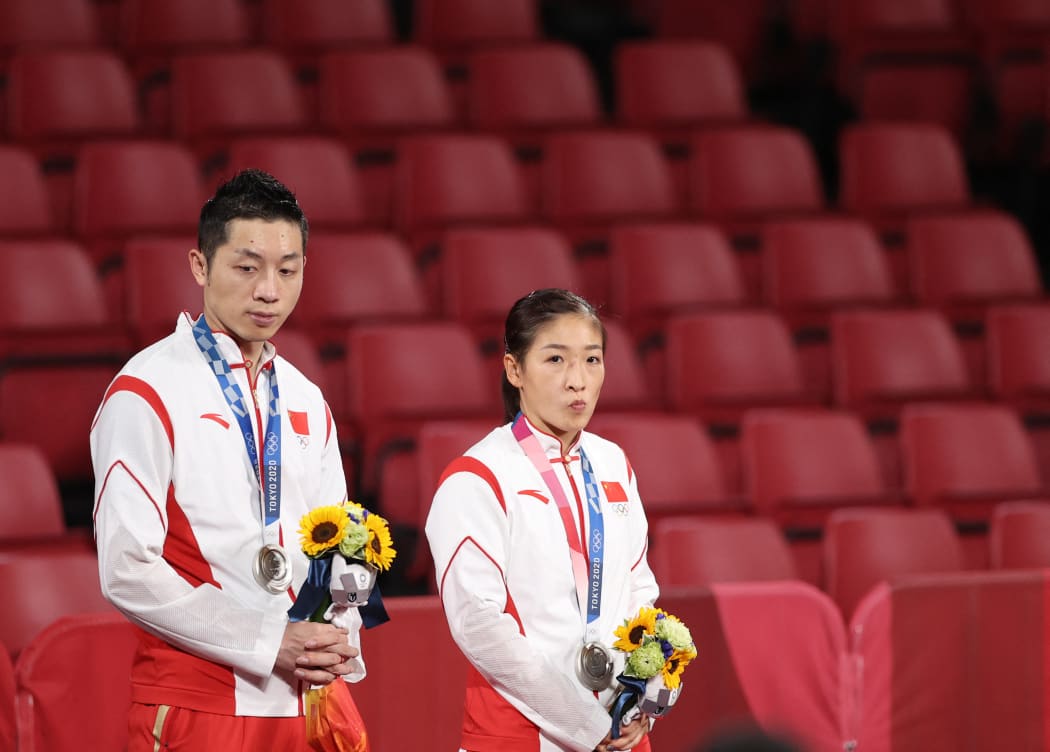 Xu Xin and Liu Shiwen of China react during the ceremony for the table tennis mixed doubles gold medal match at the Tokyo 2020 Olympic Games.