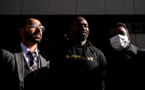 Syed Zain, left, a Japanese citizen with Pakistani origin, Maurice (first name only), a US citizen with permanent residency, and Matthew (first name only), a Pacific Islander with permanent residency, pose outside the Tokyo District Court in Tokyo on 29 January 29, 2024. (Photo by Philip FONG / AFP)