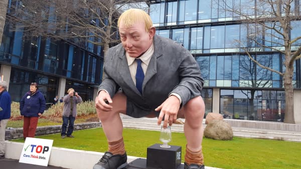 Protesters have delivered a huge statue of Environment Minister Nick Smith squatting over a glass of water to Canterbury's regional council.