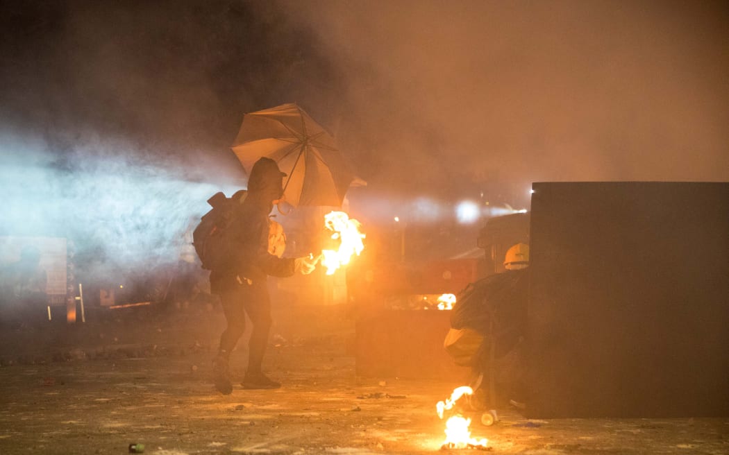A protester prepares to throw a molotov cocktail during clashes with police at the Chinese University of Hong Kong on 12 November 2019.