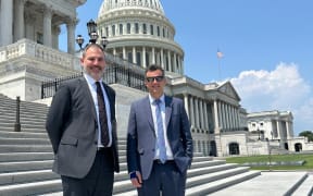 Two MPs pose for a photo in front of the Capitol building in Washington D.C.