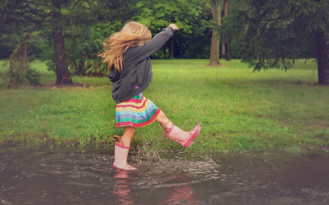 Child splashing in puddle