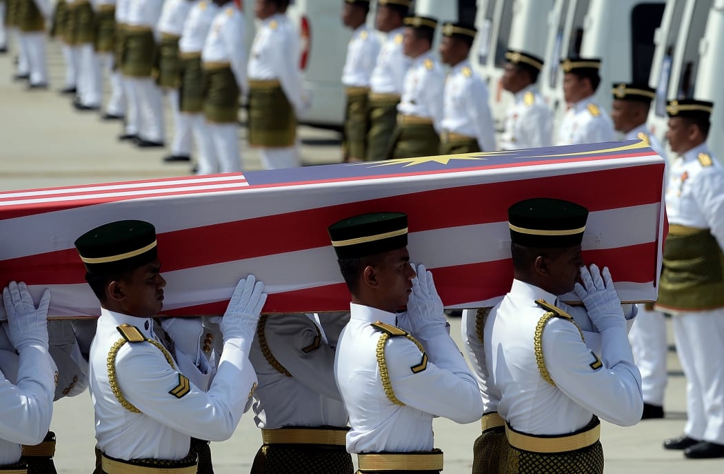 Soldiers carry a coffin with the remains of a Malaysian victim of the Malaysia Airlines flight MH17 crash during a ceremony at Kuala Lumpur International Airport.