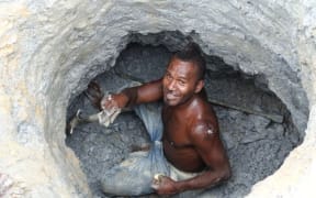 An artisinal gold miner from Nusuta village in Solomon Islands Guadalcanal Province digs for ore in Gold Ridge's pit 3 also known as Kupers.