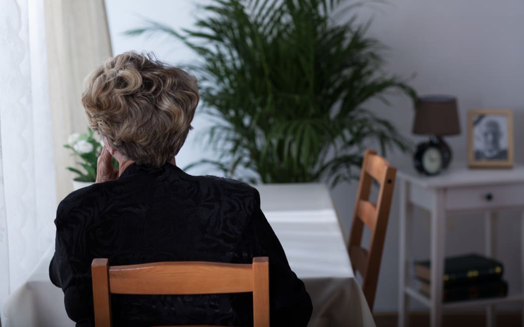 Depressed elderly widow sitting alone at home