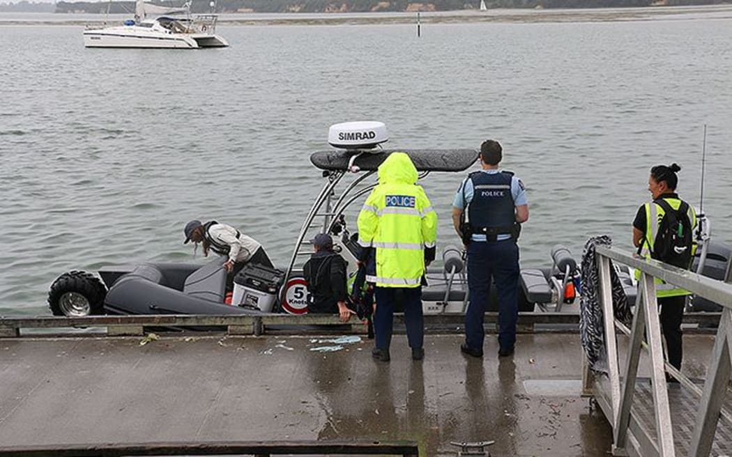 Police near the wharf in Tauranga after a skull was seen in the water.