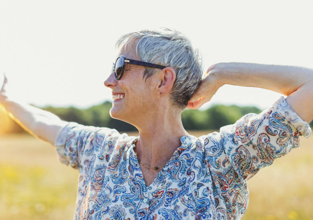 Enthusiastic senior woman with arms outstretched in sunny field. (Photo by CAIA IMAGE / SCIENCE PHOTO LIBRA / NEW / Science Photo Library via AFP)