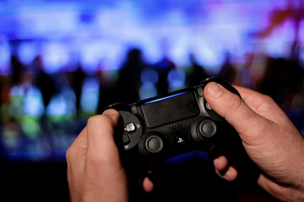 A gamer uses a PS4 controller as he plays at the new Ubisoft video game "Watch Dogs Legion"