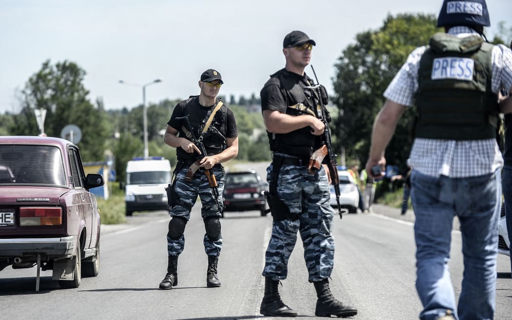 Pro-Russian militants block the road behind Dutch and Australian forensic teams on their way to the MH17 crash site.