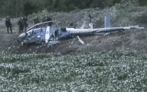 Police officers investigate the wreckage of the helicopter that was shot down during a raid on drug dealers.