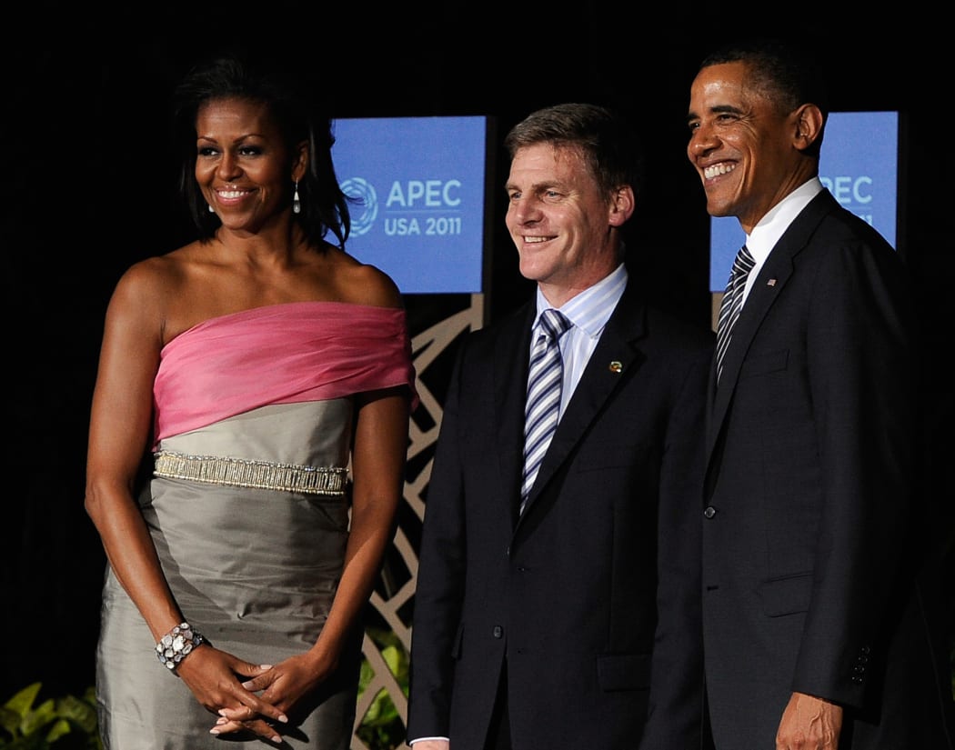 US President Barack Obama (R) and wife Michelle Obama (L) greet New Zealand Deputy Prime Minister Bill English to the Asia-Pacific Economic Cooperation (APEC) summit dinner on November 12, 2011 in Waikiki, Hawaii.