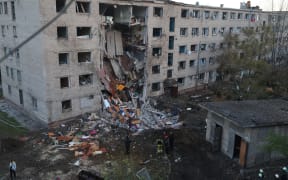 Ukrainian rescuers work at the site of a heavily damaged building following an air attack in Zaporizhzhia on October 30, 2025, amid the Russian invasion of Ukraine. Russian strikes on Ukraine overnight killed one person, wounded 17 and caused emergency power outages across the country, Ukrainian authorities said on October 30, 2025. (Photo by Marina MOISEIENKO / AFP)
