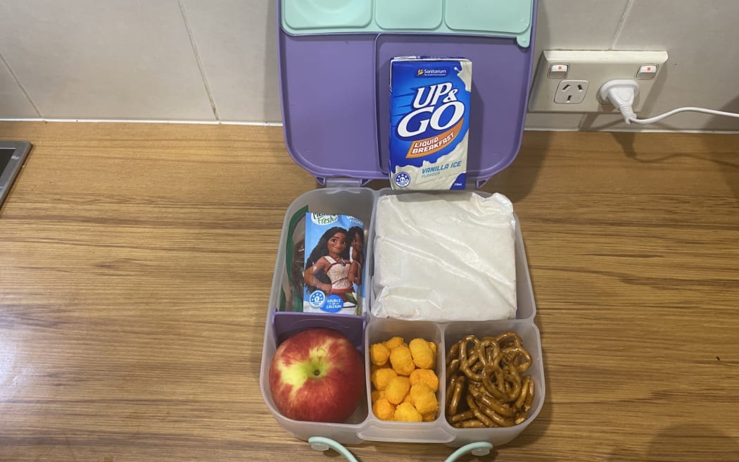 A lunch box with sandwich, pretzels, an apple, sandwich, Up&Go drink, rice poppers, and yogurt