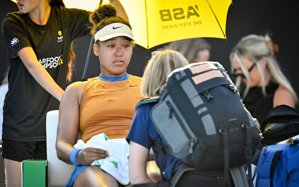 Naomi Osaka of Japan receives medical attention during her match against Clara Tauson of Denmark.