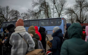 Several people and children wait to cross into Romania at the Porubne border crossing on March 5, 2022, in western Ukraine. According to the latest information, Ukraine suspended today the evacuation of civilians from Mariupol after Russia broke the ceasefire to open humanitarian corridors.