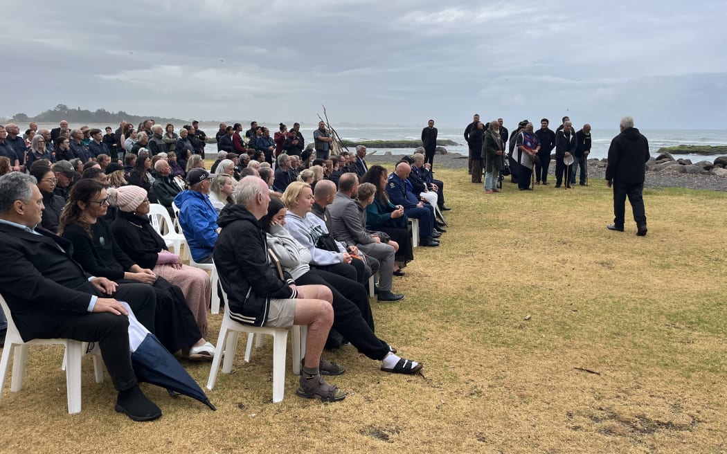Whakatāne community sitting at the waterfront as karakia is held to mark the anniversary of the Whakaari White Island Eruption.