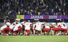 Tonga's players pray after their dramatic defeat by France.