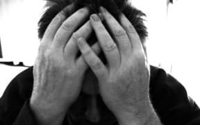 Man holding head in his hands