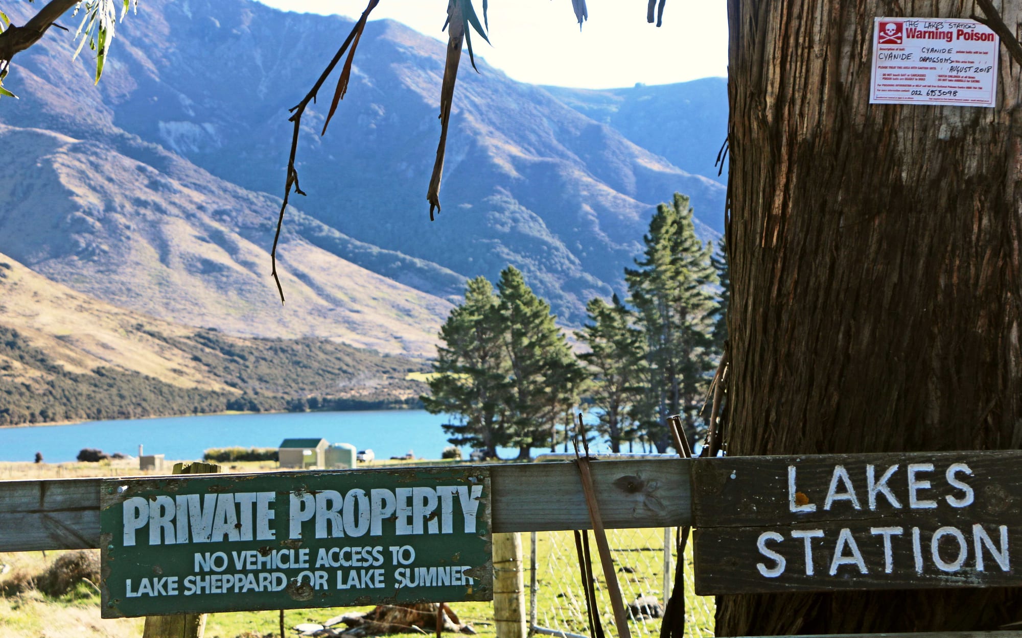 Lakes Station in North Canterbury with private property signs on fence and Lake and hills in backdrop