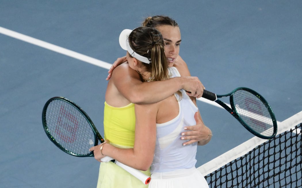 Winner Aryna Sabalenka of Belarus (L) and Spain's Paula Badosa embrace at the net after their women's singles semi-final match on day twelve of the Australian Open tennis tournament in Melbourne on January 23, 2025. (Photo by Yuichi YAMAZAKI / AFP) / -- IMAGE RESTRICTED TO EDITORIAL USE - STRICTLY NO COMMERCIAL USE --