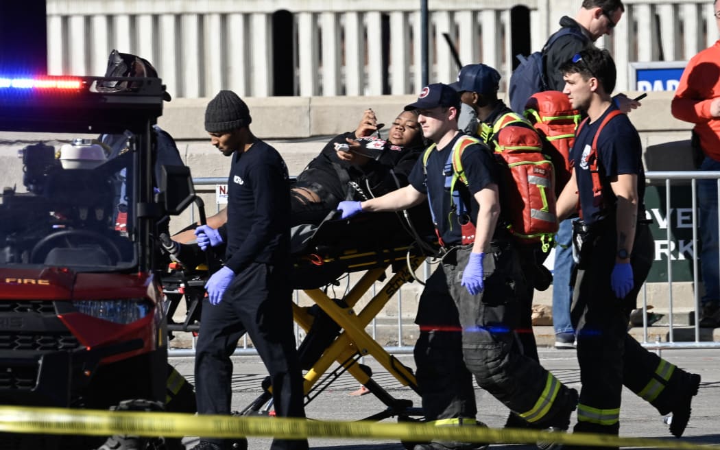 First responders tend to an injured person as they bring her out of Union Station near the Kansas City Chiefs' Super Bowl LVIII victory parade on February 14, 2024, in Kansas City, Missouri. Multiple people were injured after gunfire erupted at the Kansas City Chiefs Super Bowl victory rally on Wednesday, local police said. (Photo by ANDREW CABALLERO-REYNOLDS / AFP)