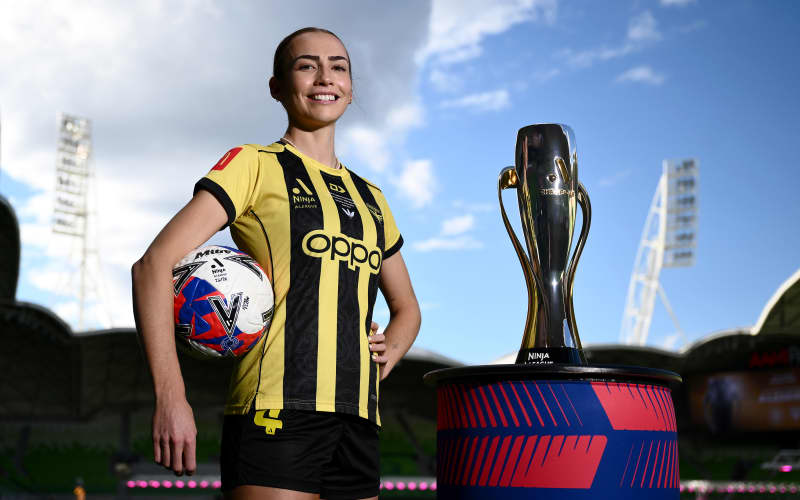 Mackenzie Barry of the Wellington Phoenix poses with the A-League women trophy at AAMI Park, in Melbourne.