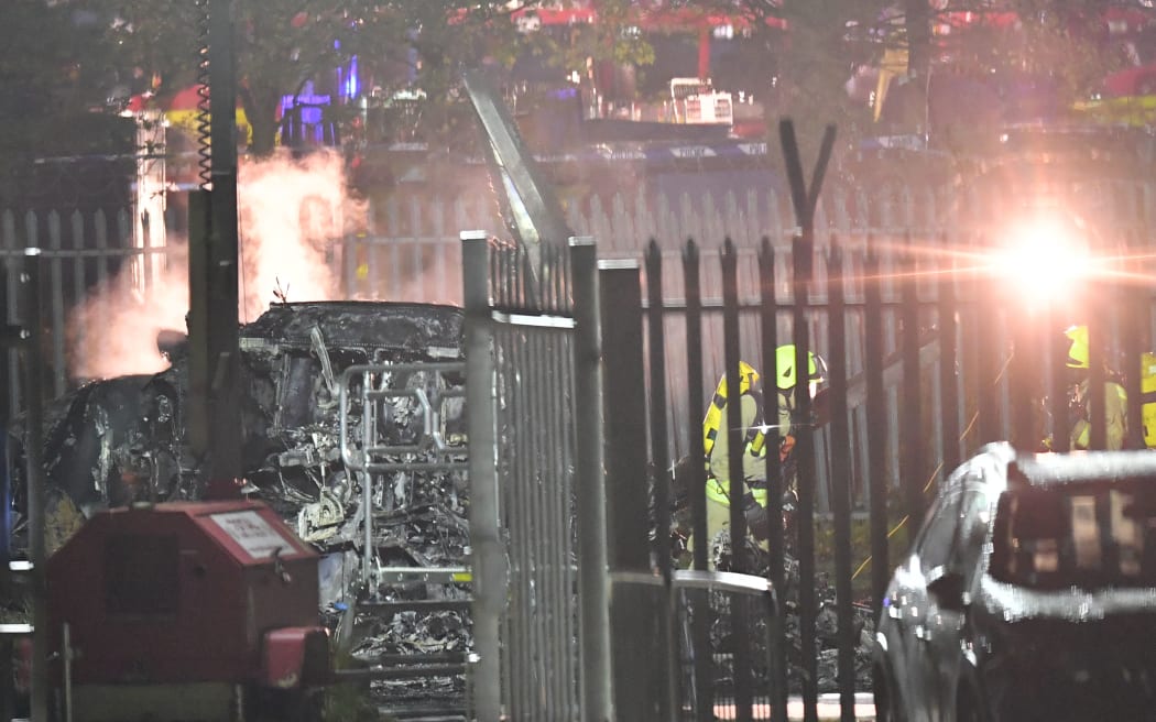 Emergency services work at the scene on the wreckage of a helicopter that crashed in a car park outside Leicester City Football Club's King Power Stadium in Leicester, England.