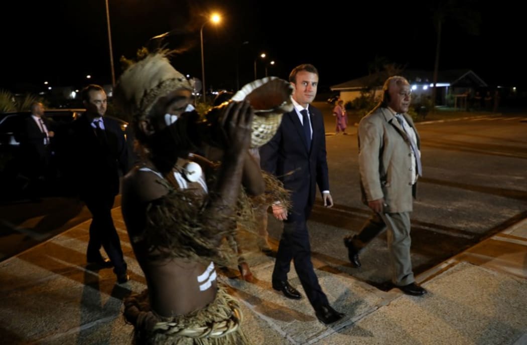 French President Emmanuel Macron (C) walks with President of the 'Senat Coutumier' Pascal Sihaze (R) and others as he arrives to attend a welcoming ceremony at The Coutumier Senate in Noumea on May 3, 2018.