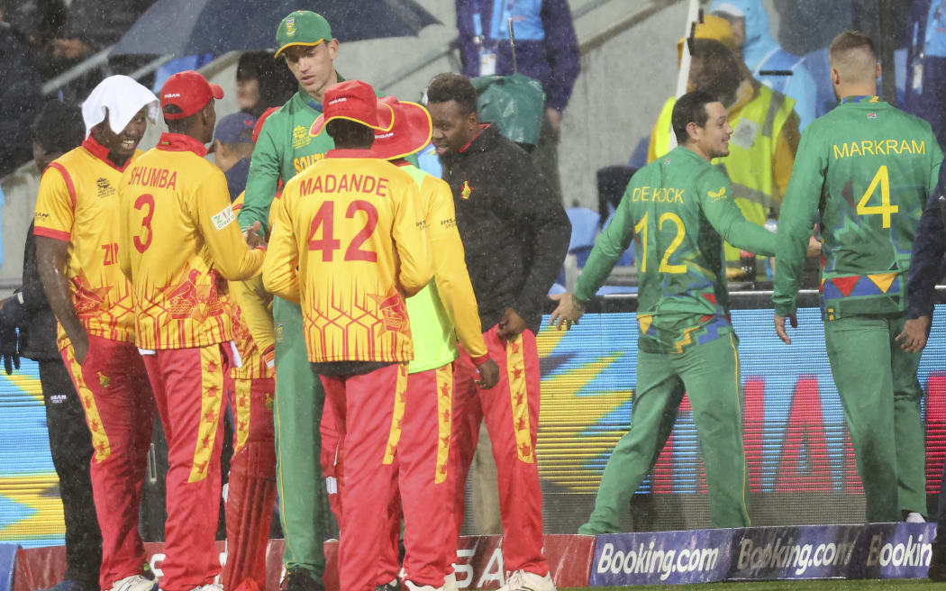 South Africa and Zimbabwe players shake hands after the play being called off during the ICC men's Twenty20 World Cup 2022 cricket match between South Africa and Zimbabwe at Bellerive Oval in Hobart on October 24, 2022. (Photo by DAVID GRAY / AFP) / -- IMAGE RESTRICTED TO EDITORIAL USE - STRICTLY NO COMMERCIAL USE --