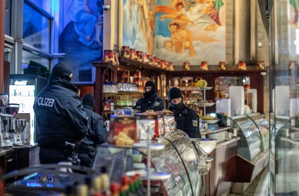 05 December 2018, North Rhine-Westphalia, Duisburg: Policemen are standing in an ice cream parlour in the Citypalais in downtown Duisburg. Investigators in Germany, Italy, the Netherlands and Belgium have raided members of the Italian mafia organisation 'Ndrangheta.