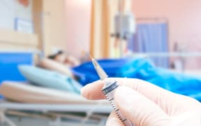 Medical syringe in the doctor's hands on the patient's in room hospital blur background