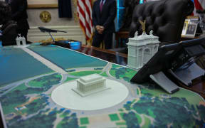 A plan for an arch across from the Lincoln Memorial is seen on the Resolute Desk as US President Donald Trump meets with Finnish President Alexander Stubb and Prime Minister Petteri Orpo in the Oval Office of the White House in Washington, DC, on October 9, 2025. (Photo by Jim WATSON / AFP)