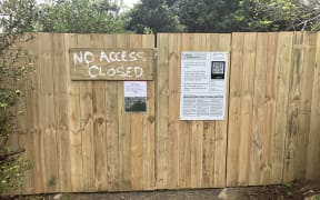 A bare timber fence with a sign reading "NO ACCESS - CLOSED" blocks a dirt path.