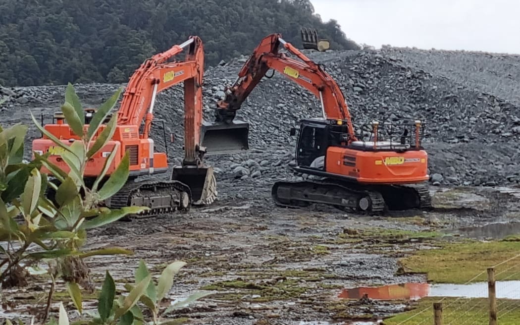 Diggers at work on the stopbank protecting the town, last winter.